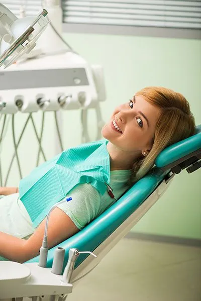 woman smiling in the dental chair after getting same-day dental crowns