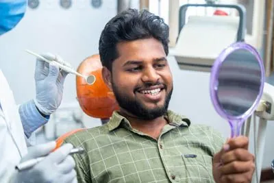 patient smiling in the mirror after his dental procedure