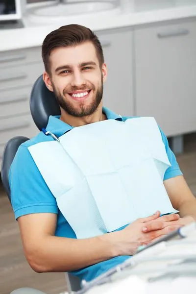 man showing off his restored smile after getting a dental implant