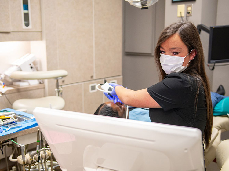 Dental assistant at Meyer Dentistry working on a patient in the dental chair
